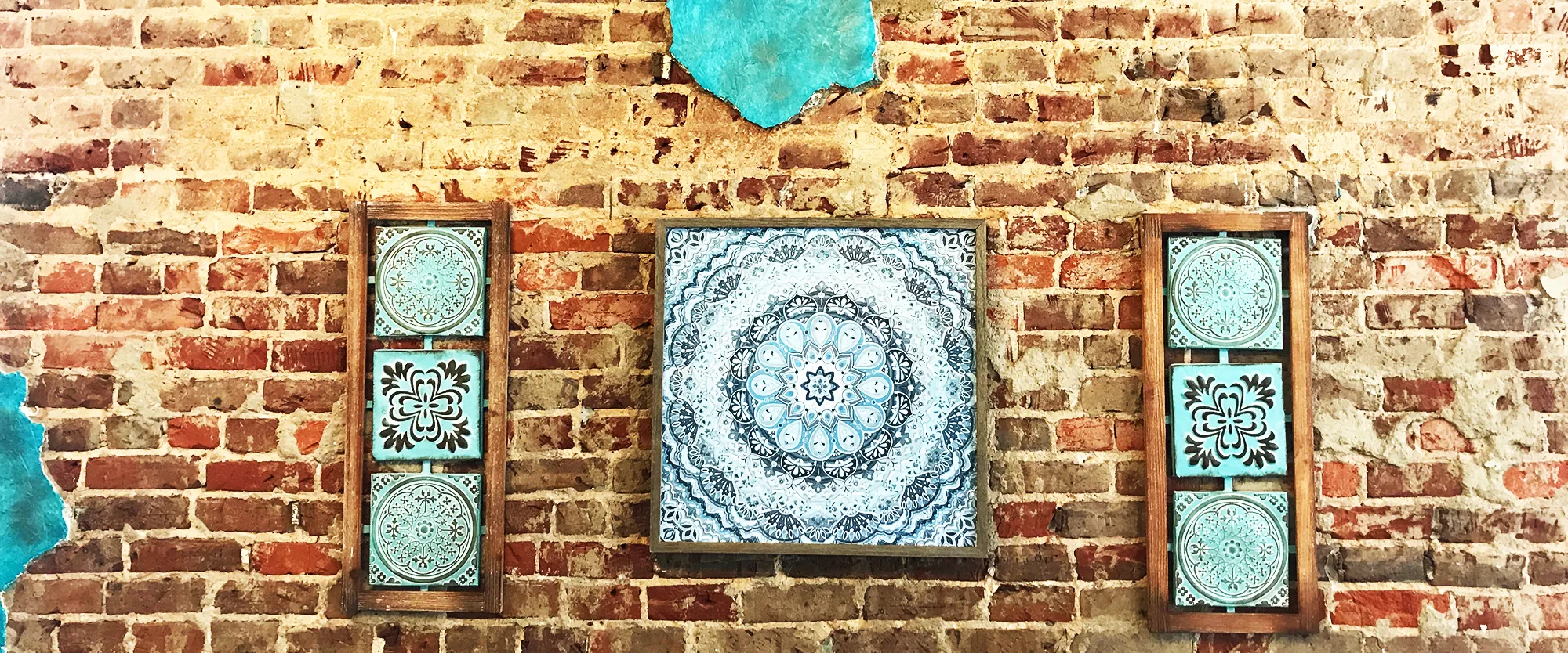Mediterranean tile art on the historic brick wall at Jafar's